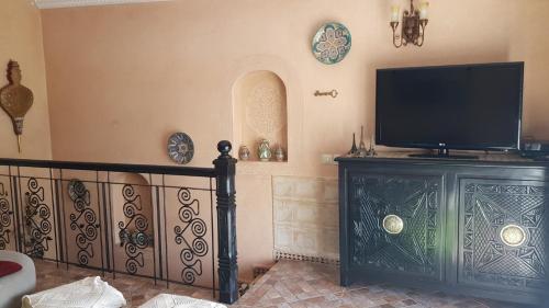 sala de estar con TV de pantalla plana en la pared en Havre de paix pied dans l'eau en Agadir