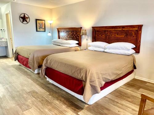 Best Inn Texas في Levelland: سريرين في غرفة الفندق بسريرين