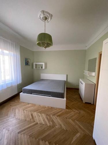 a bedroom with a bed and a chandelier at Guest house, Jūrmala in Jūrmala