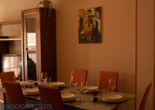 a dining room table with chairs and a table with wine glasses at Rapadoira Seaside Apartment in Foz