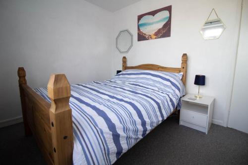 a bedroom with a bed with a blue and white striped comforter at Lovely 5 Berth Chalet In The Coastal Village Of Hemsby Ref 18164b in Hemsby