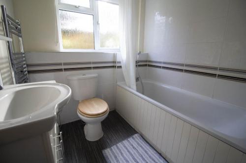 a bathroom with a toilet and a tub and a sink at Lovely 5 Berth Chalet In The Coastal Village Of Hemsby Ref 18164b in Hemsby