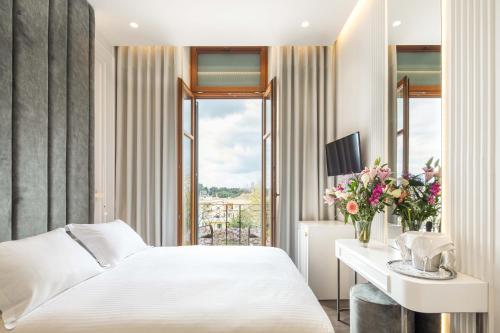 a hotel room with a bed and a desk and a window at Bella Venezia in Corfu