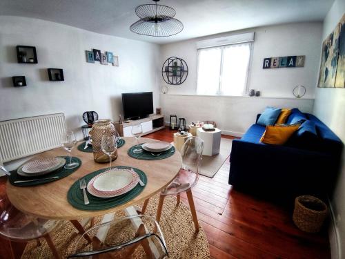un salon avec une table et un canapé dans l'établissement Le char'Mans appartement cosy proche gare et tram, au Mans