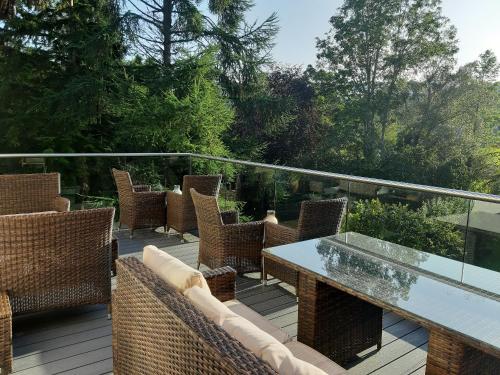 a patio with chairs and a table on a deck at Tir y Coed Country House in Conwy