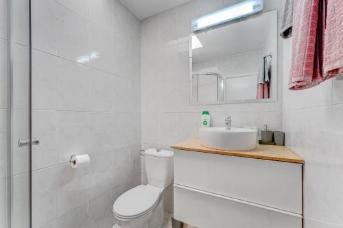 bagno bianco con servizi igienici e lavandino di Cozy apartment in Costa del Silencio a Costa Del Silencio