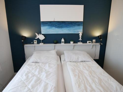 two beds in a bedroom with a picture on the wall at Badhotel Callantsoog in Callantsoog