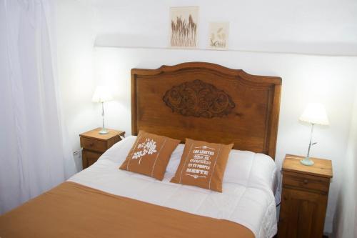 Un dormitorio con una cama con dos mesitas de noche y dos lámparas. en Cabañas Los 2 Algarrobos, en Santa Rosa de Calamuchita