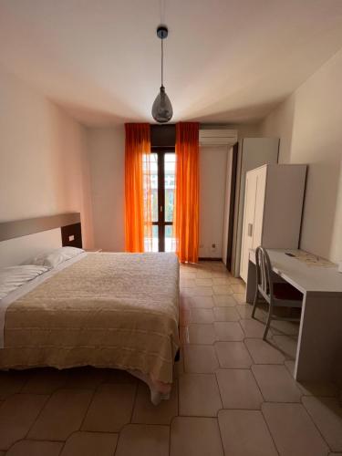 a bedroom with a bed and a desk and a window at Appartamenti Aspromonte in Milan