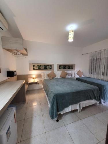 a bedroom with two beds and a table in it at Pousada Riacho dos Milagres in São Miguel dos Milagres