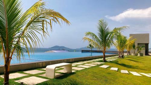 a pool with palm trees and a bench next to it at Kids Love It! Fantastic Seaview with Infinite Pool, 5min to jetty, Food Spot-MangoHouse2 in Kota Kinabalu