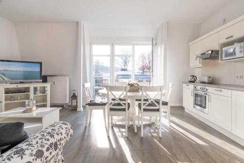 een keuken en een woonkamer met een tafel en stoelen bij Villa Marin Wohnung 25 in Zinnowitz