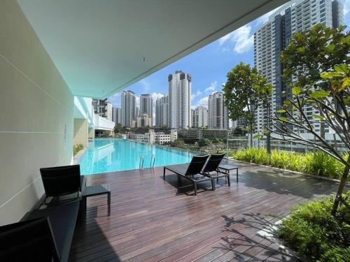 een balkon met stoelen en een zwembad in een gebouw bij Inspirasi Mont Kiara 3 Rooms Balcony Free WIFI & Carpark By The Homez in Kuala Lumpur