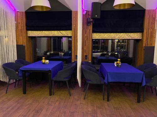 uma sala de jantar com mesas azuis e cadeiras azuis em Rikabar Restaurant & nature em Bila Tserkva