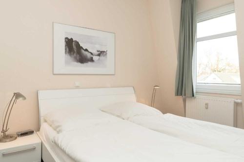 1 cama blanca en un dormitorio con ventana en Villa Marin Wohnung 24 en Zinnowitz