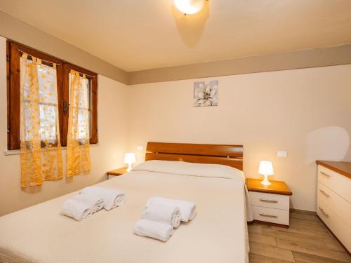 um quarto com uma cama branca e toalhas em Anxur Village Camping em Terracina