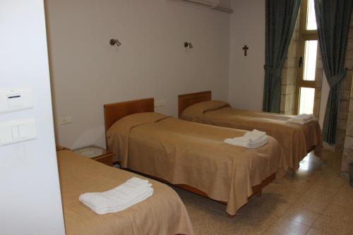 Pokój z 3 łóżkami i krzyżem na ścianie w obiekcie The Bridgettine Sisters Monastery w Jerozolimie
