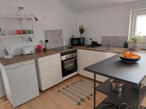 a kitchen with a bowl of fruit on a table at Casa Alegria - The Orangery 