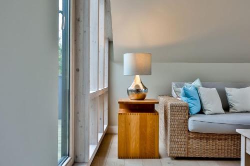 a living room with a couch and a lamp on a table at Kontorhaus Keitum in Keitum