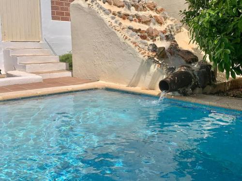 a water fountain in a swimming pool at Villa urbana con Piscina en Playa den Bossa in Ibiza Town