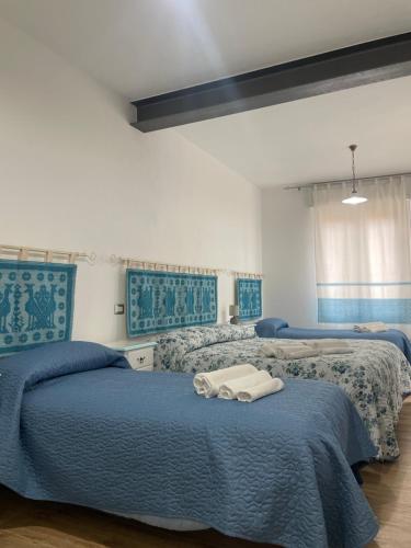 2 camas en una habitación de color azul y blanco en Affittacamere Il Vicoletto Aria Ona, en Villagrande Strisaili