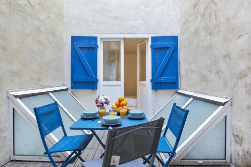 a blue table and chairs on a balcony with blue doors at Flat with typical charm and terrace - Bayonne - Welkeys in Bayonne