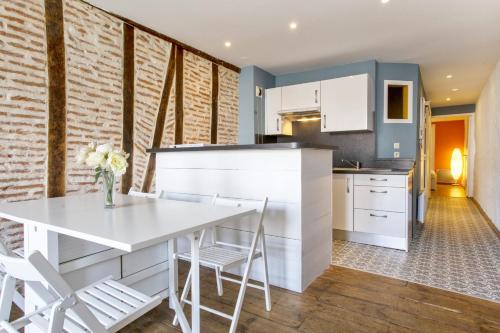 a kitchen and dining room with a white table and chairs at Flat with typical charm and terrace - Bayonne - Welkeys in Bayonne