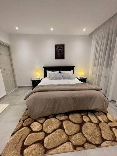 a bedroom with a large bed with two night stands at Logement Chic, résidence azaléa - Alger in Draria