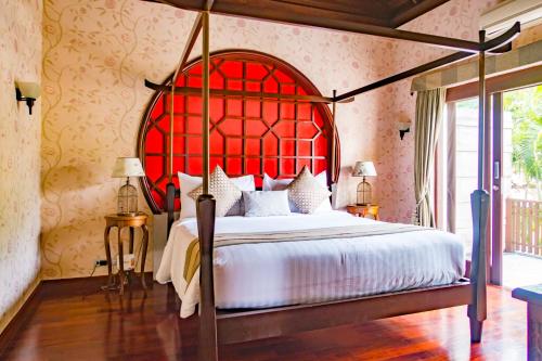 a bedroom with a large bed with a red headboard at Pawanthorn Samui - SHA Plus in Chaweng