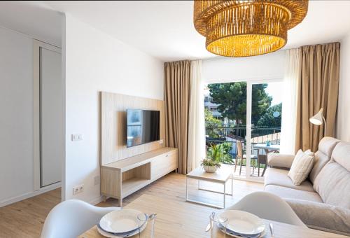 Martinez Apartments في بالمانوفا: غرفة معيشة مع أريكة وتلفزيون
