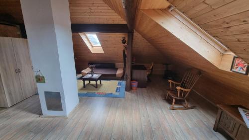 an attic room with a couch and a chair at Guest House Arvaj in Kranj