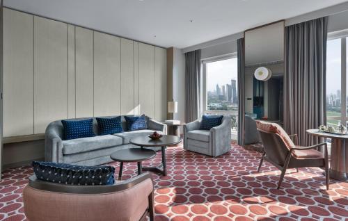 a living room with a couch and a table and chairs at Four Seasons Hotel Mumbai in Mumbai