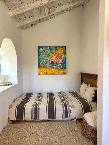 1 cama en una habitación con un cuadro en la pared en Lillys märchenhafte Finca Rural, en Granadilla de Abona