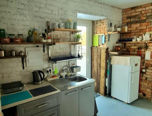 a kitchen with a sink and a white refrigerator at Gluosnių vila - Adutiškio pirtis in Švenčionys