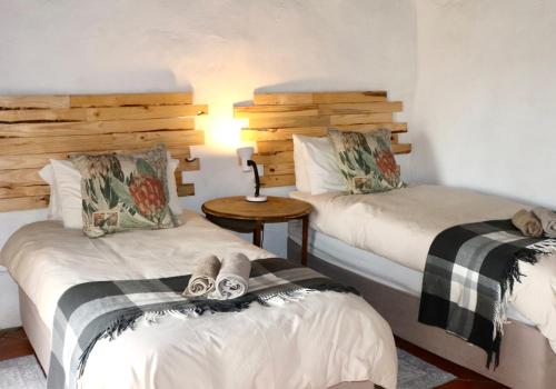 a bedroom with two beds and a table with a lamp at Harmony Game Lodge in Middlerus