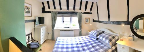 een woonkamer met een bank en een raam bij Bakers Cottage Ludham - Norfolk Broads in Ludham