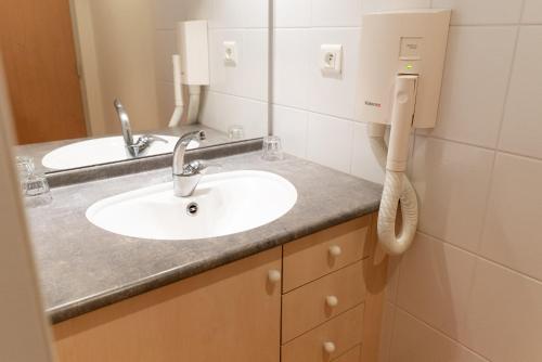 a bathroom with two sinks and a phone at Azureva Métabief in Métabief