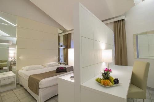 una camera d'albergo con letto e cesto di frutta di Costa Rey Wellness & Spa a Costa Rei