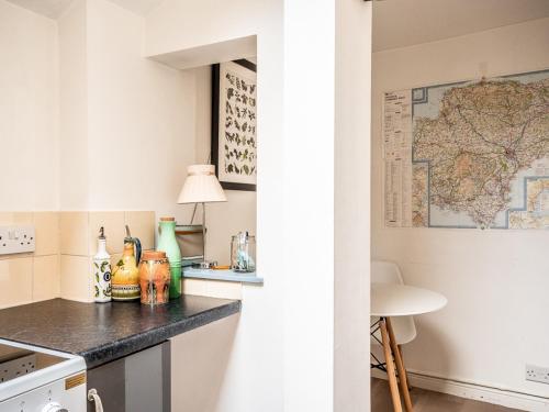 a kitchen with a counter and a map on the wall at Pass the Keys Cottage with garden tucked away in central Exeter in Exeter