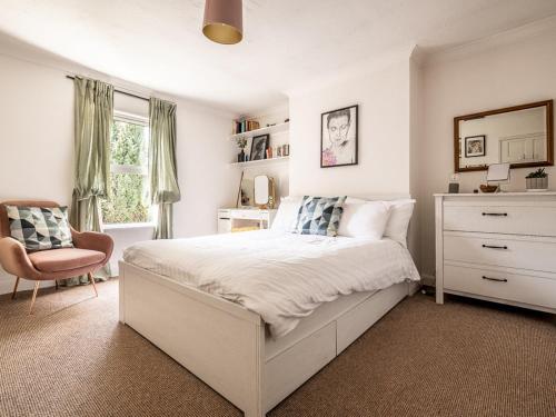 a bedroom with a bed and a chair and a window at Pass the Keys Cottage with garden tucked away in central Exeter in Exeter
