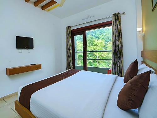 ein Schlafzimmer mit großem Bett und Fenster in der Unterkunft Mist Wayanad in Wayanad