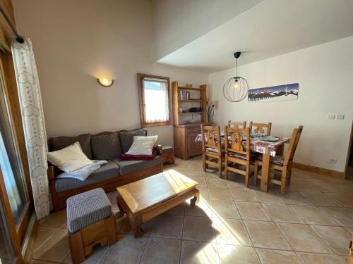 un salon avec un canapé et une table dans l'établissement Appartement T3 confortable avec balcon, centre village, proche ski-bus, animaux acceptés - FR-1-624-49, à Samoëns