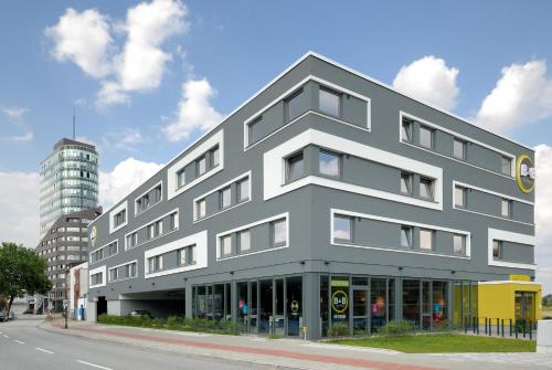 un edificio gris al lado de una calle en B&B Hotel Hamburg-Harburg en Hamburgo