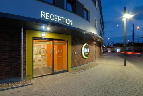 ein Geschäft mit orangefarbenen Türen an einem Gebäude in der Unterkunft B&B Hotel Hamm in Hamm