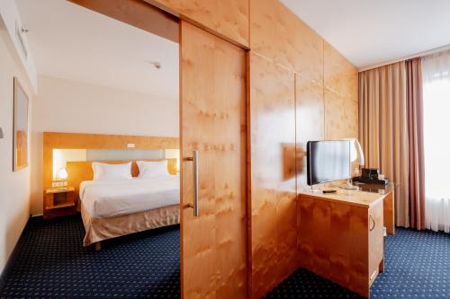 ゲルゼンキルヒェンにあるstays by friends Gelsenkirchenのベッドとテレビが備わるホテルルームです。