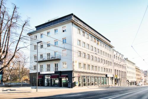 ein weißes Gebäude an der Ecke einer Straße in der Unterkunft B&B Hotel Graz-Hbf in Graz