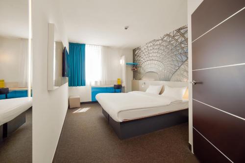 a hotel room with two beds and a door at B&B Hotel Katowice Centrum in Katowice