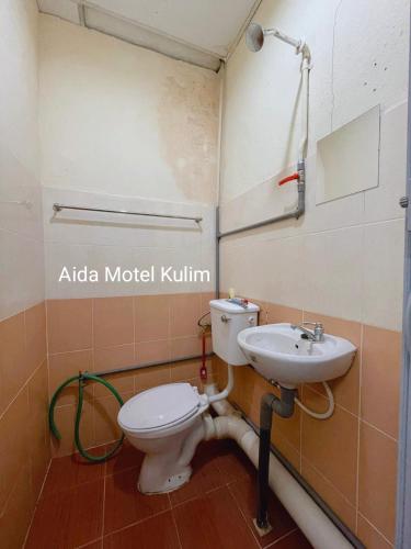 a bathroom with a toilet and a sink at Art Motel Kulim in Kulim