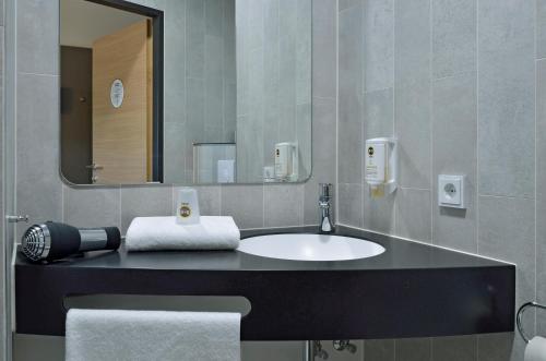 łazienka z umywalką i lustrem w obiekcie B&B Hotel Graz City-Süd w Grazu