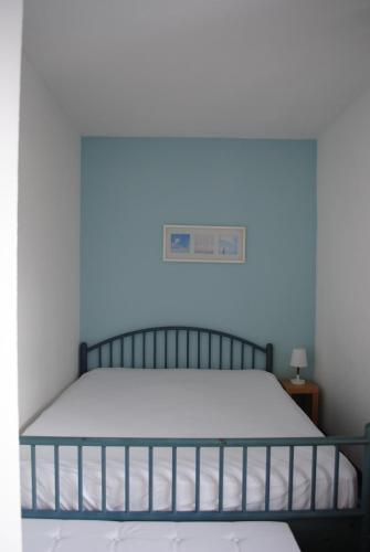 a bed in a bedroom with a blue wall at Landhaus Steinbrech in Grainau